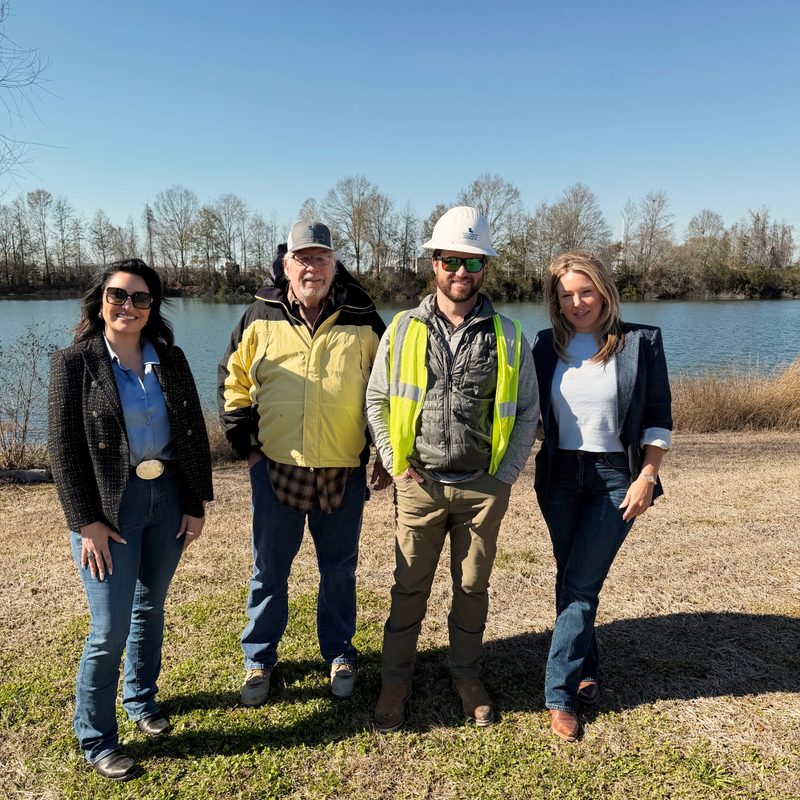 BPK team walking the project alongside hardhat-clad clients near a lake